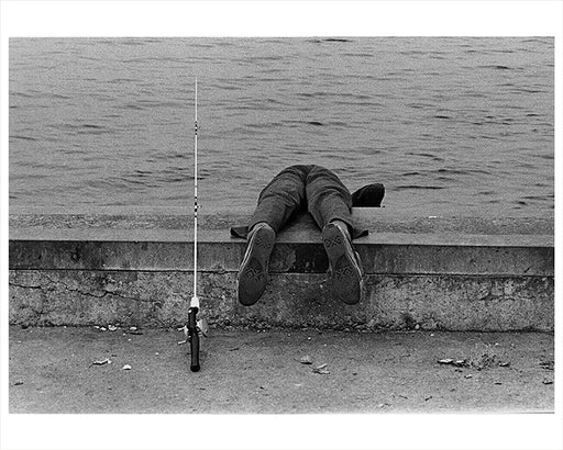 A boy hangs over the edge while fishing at Canarsie Pier, Brooklyn, New York 1972